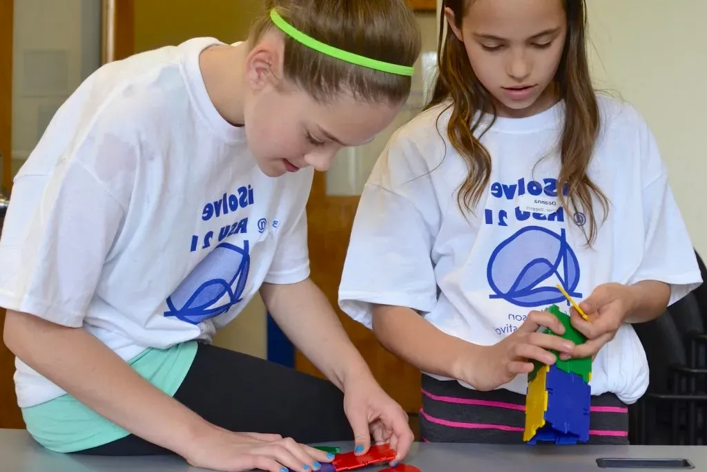 Two young girls putting puzzle pieces together