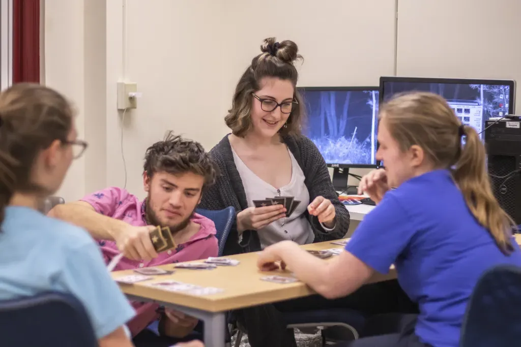 Four students playing a card game