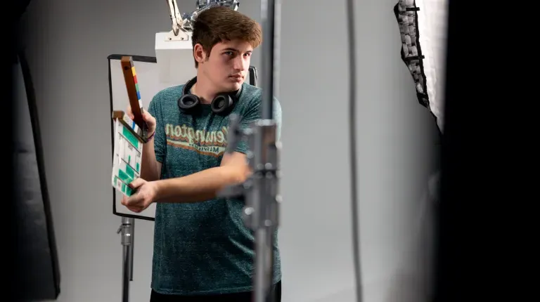 A UNE student claps a production slate