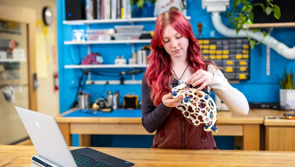 A student holds up a device to measure brain activity