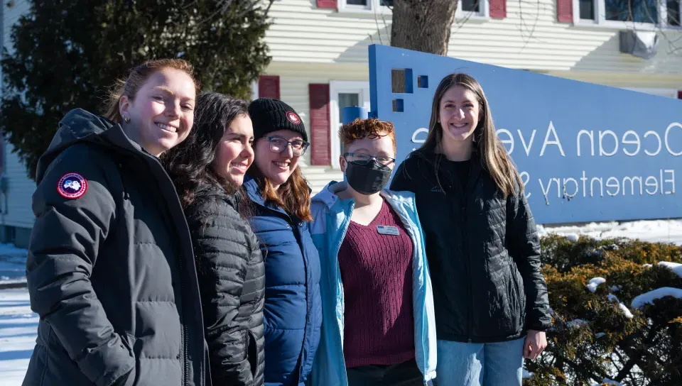 UNE students pose for a photo outside Ocean Avenue Elementary School