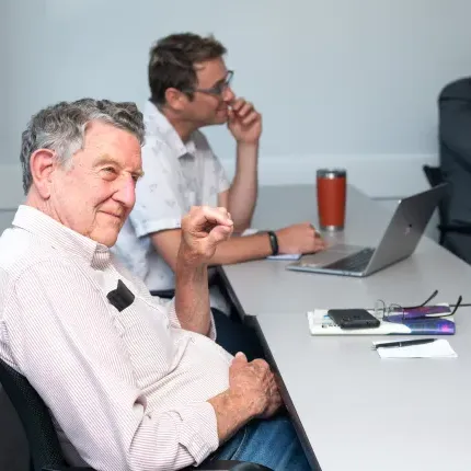 Faculty members watch student presentations from the classroom seats