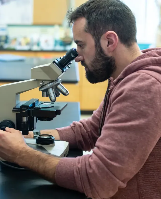 A student peers into a microscope