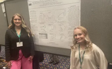 Lily Bennett, ’25 (left), and Hannah LaCourse, ‘23 (right) at the 2023 USASP meeting at Duke University in front of their poster.