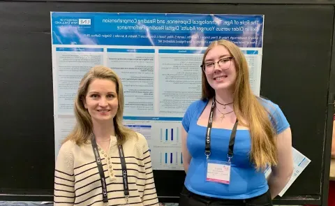 Emily Newborough poses with Jennifer Stiegler-Balfour in front of their research poster