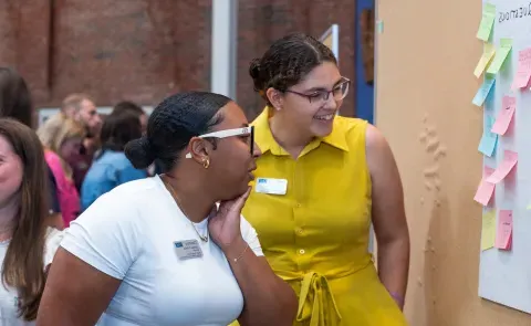 two students engage with questions on sticky notes