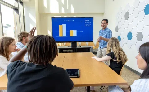 person lectures in front of students in college of business