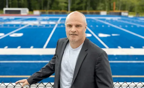 Portrait of Norm O'Reilly with the UNE football field in the background